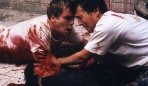 Dr. Lawrence Gordon (Elwes) and Adam Stanheight (Whannell) become brothers in blood on Saw's dingy bathroom floor.